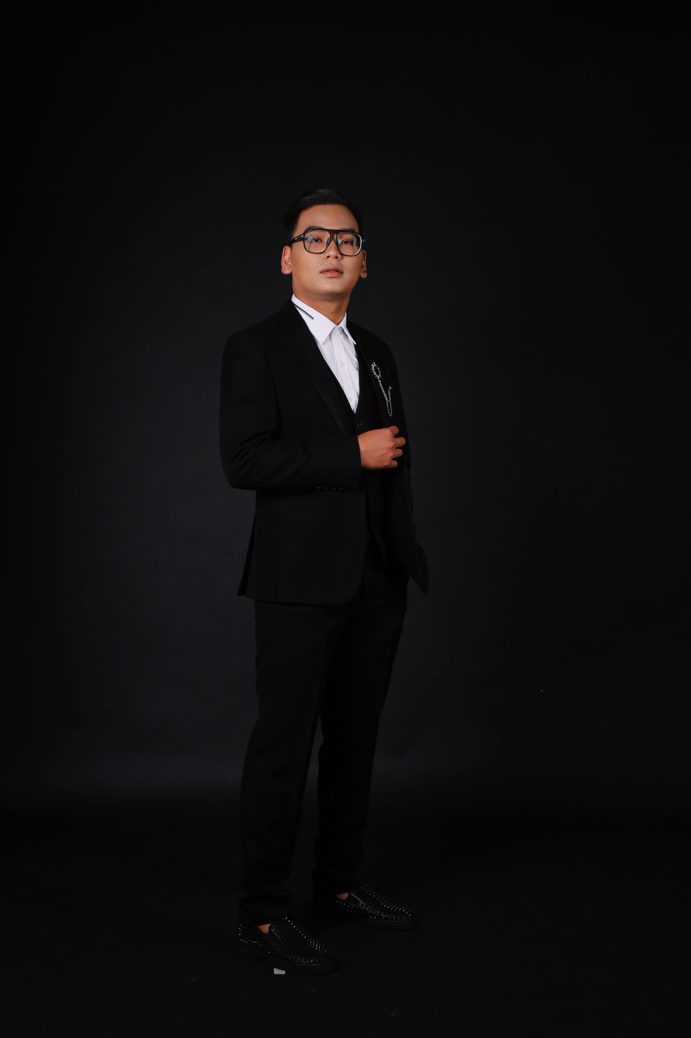 Full-length portrait of DYAN. in a black suit